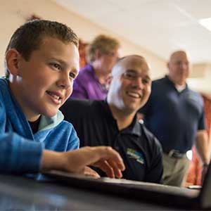 a teacher working with a student on a laptop