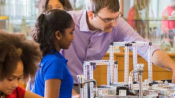 A teacher helping a student during an activity